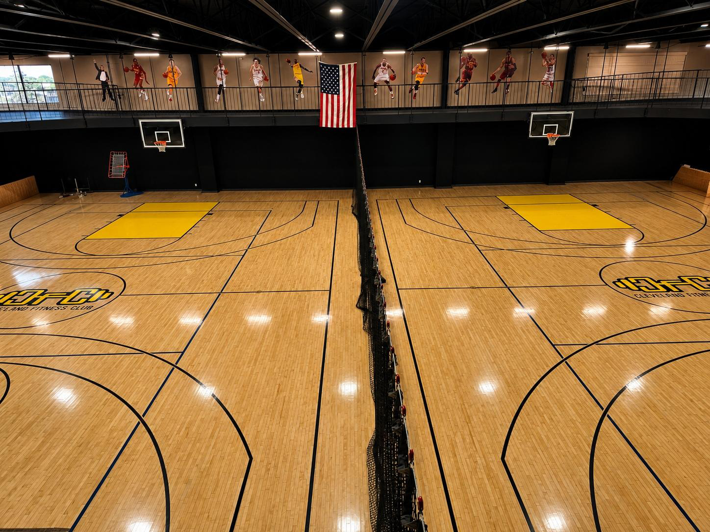 Full-size basketball court at Cleveland Fitness Club with hardwood floor and team logos at center court