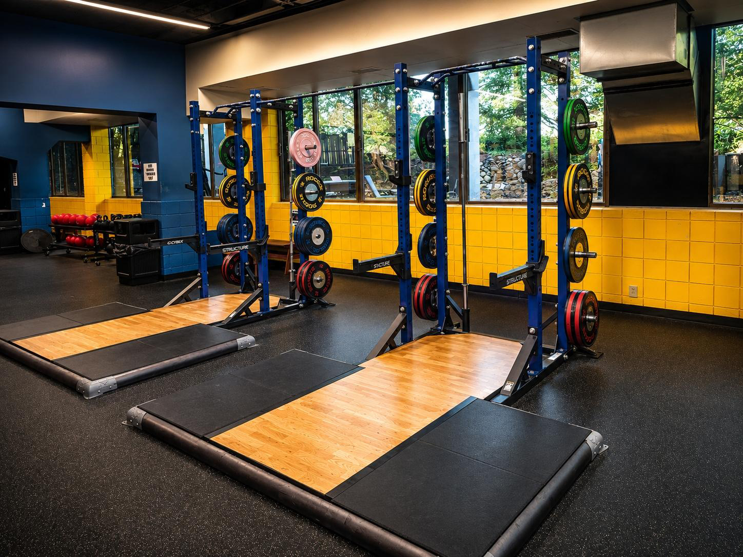 Dedicated Olympic lifting platform with rubberized floor and safety bars at Cleveland Fitness Club